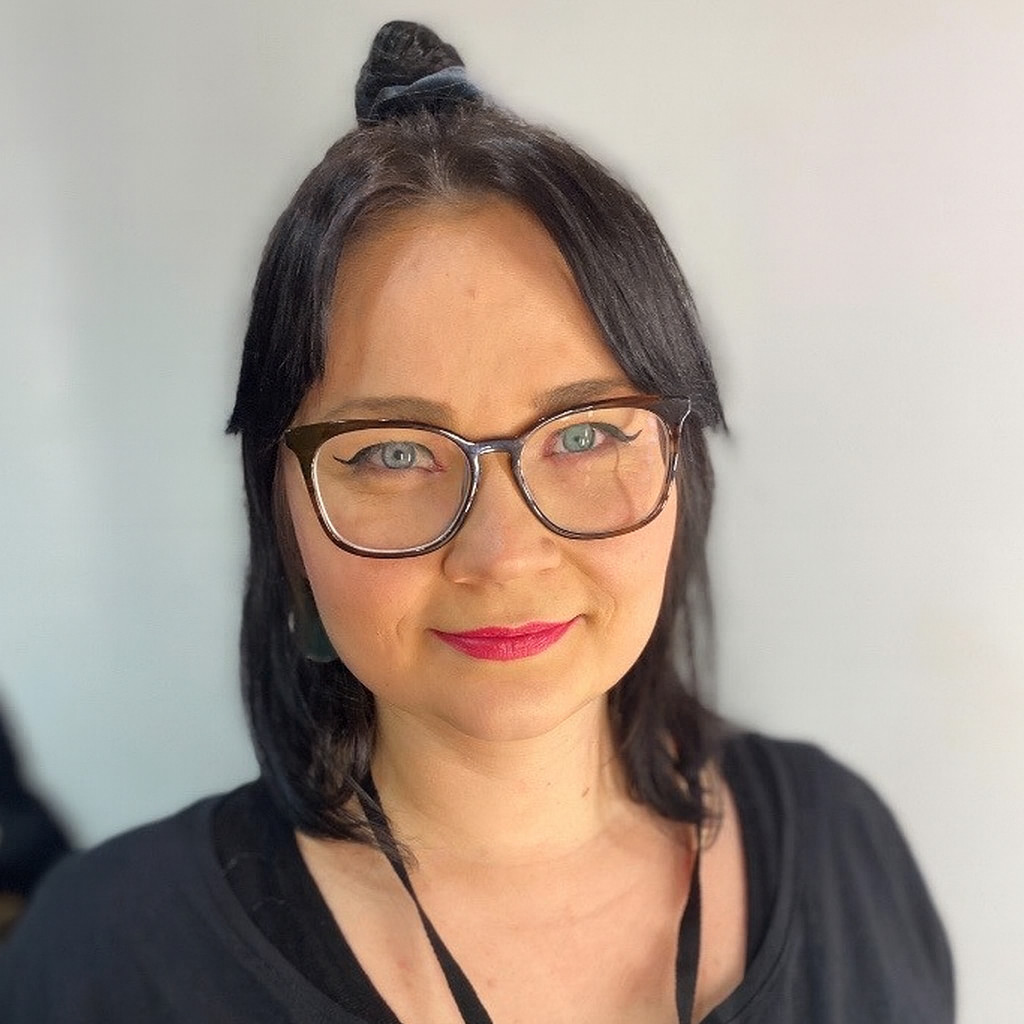 Marta Tarasewicz, Jugendbildungsreferentin. Schwarze schulterlange Haare, dunkle Brille, roter Lippenstift